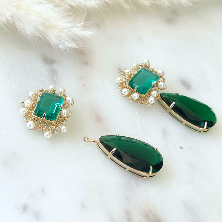 Seitenansicht des Anhänger Sets, betont die Tiefe der grünen Kristalle und die filigrane Fassung