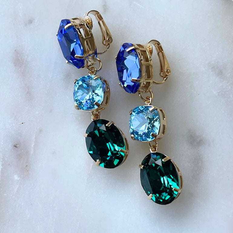 Erleben Sie die Eleganz der "GLOW"-Ohrringe mit blau-grünen Kristallen. Die grüne Basis kann separat getragen werden und verleiht einen dezenten, dennoch wunderschönen Touch. Die weltberühmten Kristalle sorgen für Glanz und zeitlose Eleganz