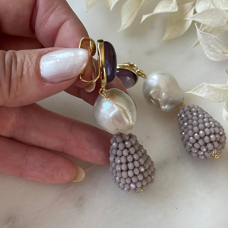 Lila Ohrclips CHARLOTTE: Amethist, Barrockperlen und Kristalle. Länge: 7,0 cm. Verstellbarer Clip-Verschluss für optimalen Tragekomfort. Ein vielseitiger Ohrring mit brasilianischem Amethyst, Barrockperlen und funkelnden Kristallen. Perfekt für formelle Anlässe und lässige Veranstaltungen, verleiht er Ihrem Look Klasse und Stil
