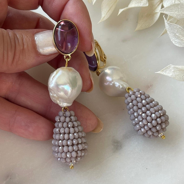 Lila Ohrclips CHARLOTTE: Amethist, Barrockperlen und Kristalle. Länge: 7,0 cm. Verstellbarer Clip-Verschluss für optimalen Tragekomfort. Ein vielseitiger Ohrring mit brasilianischem Amethyst, Barrockperlen und funkelnden Kristallen. Perfekt für formelle Anlässe und lässige Veranstaltungen, verleiht er Ihrem Look Klasse und Stil