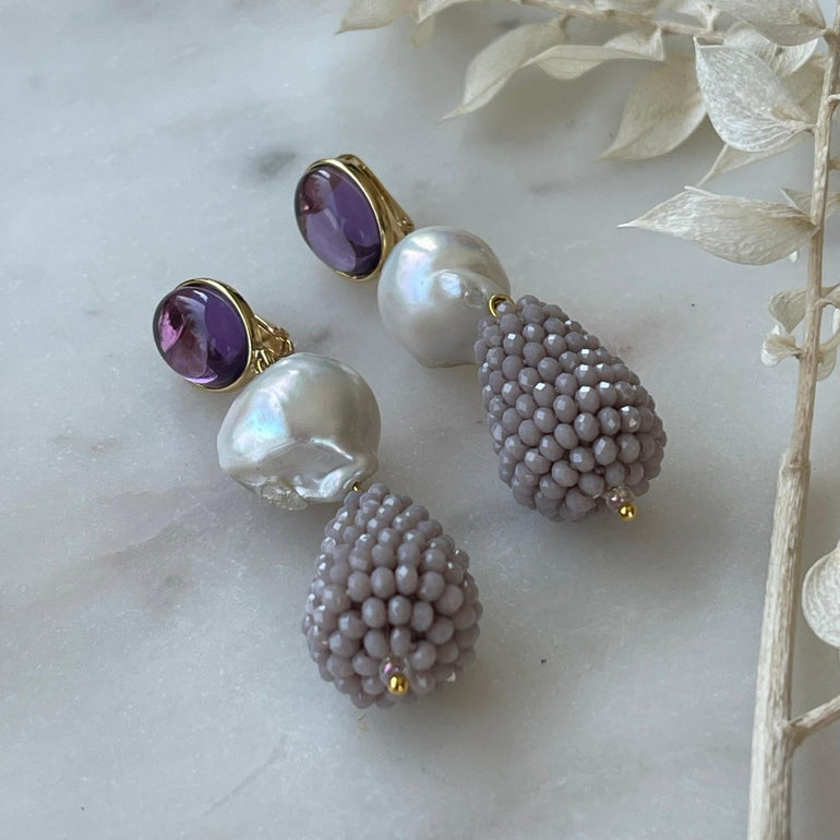 Lila Ohrclips CHARLOTTE: Amethist, Barrockperlen und Kristalle. Länge: 7,0 cm. Verstellbarer Clip-Verschluss für optimalen Tragekomfort. Ein vielseitiger Ohrring mit brasilianischem Amethyst, Barrockperlen und funkelnden Kristallen. Perfekt für formelle Anlässe und lässige Veranstaltungen, verleiht er Ihrem Look Klasse und Stil