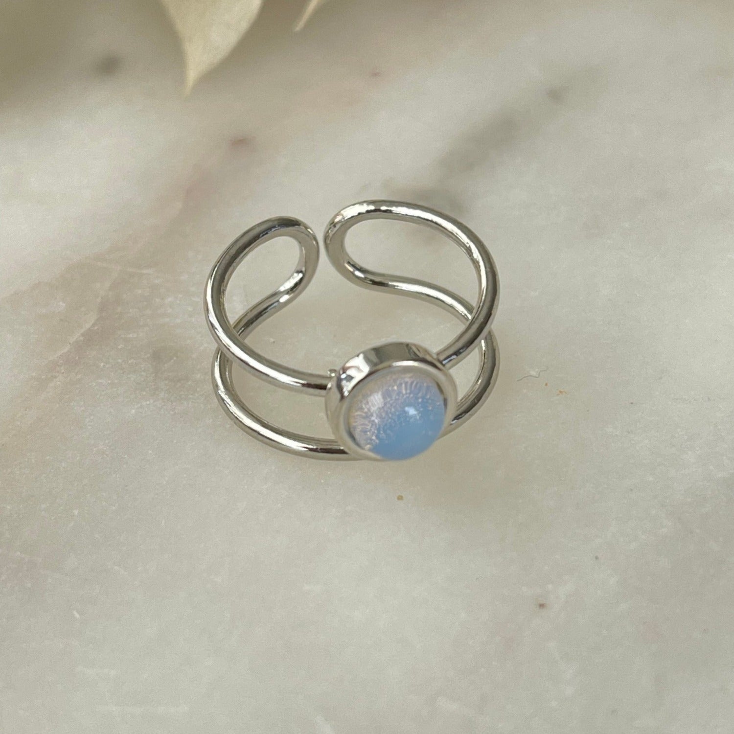Der Ring "Mel" mit opalisierendem Stein strahlt pure Eleganz aus. Ein offener, verstellbarer Cocktailring. Dieser Ring ist perfekt für Frauen, die elegante und auffällige Stücke schätzen