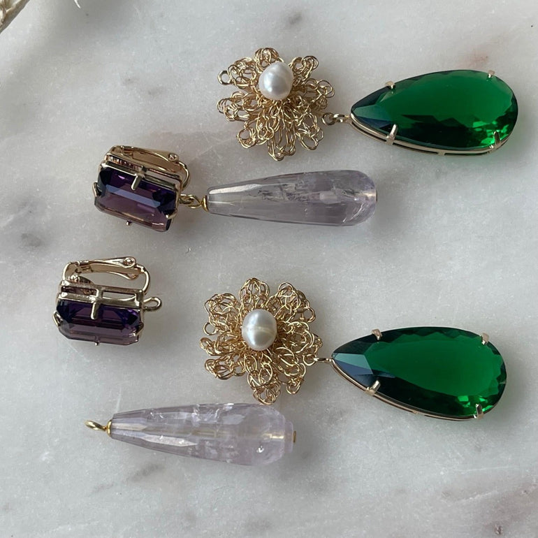Ohrclip LE CLOS NORMAND: Eleganter und vielseitiger Schmuck mit grünen und lila Kristallen. Clip-Verschluss, Länge: 6,7 cm, Breite: 1,1 cm. 18 K vergoldetes Messing mit funkelnden Kristallen in den Farben Lila und Smaragd. Enthält ein komplettes Ohrring-Paar sowie zusätzliche lila Kristalle für vielseitiges Styling