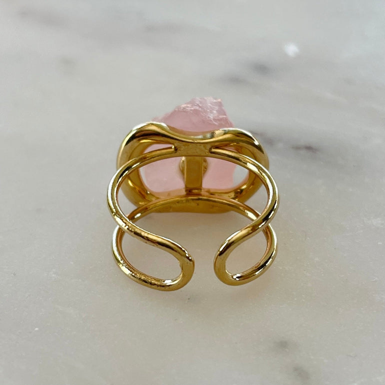 Der Ring "ÉRIKA", vergoldet mit 18 K Rosenquarz, ist ein unverwechselbares Stück.  Ein offener Cocktailring in transparentem Design. Verstellbar.  Hergestellt aus hochwertigem 18 K vergoldetem Messing mit Quarz. Perfekt für Frauen, die besondere und einzigartige Stücke zu schätzen wissen