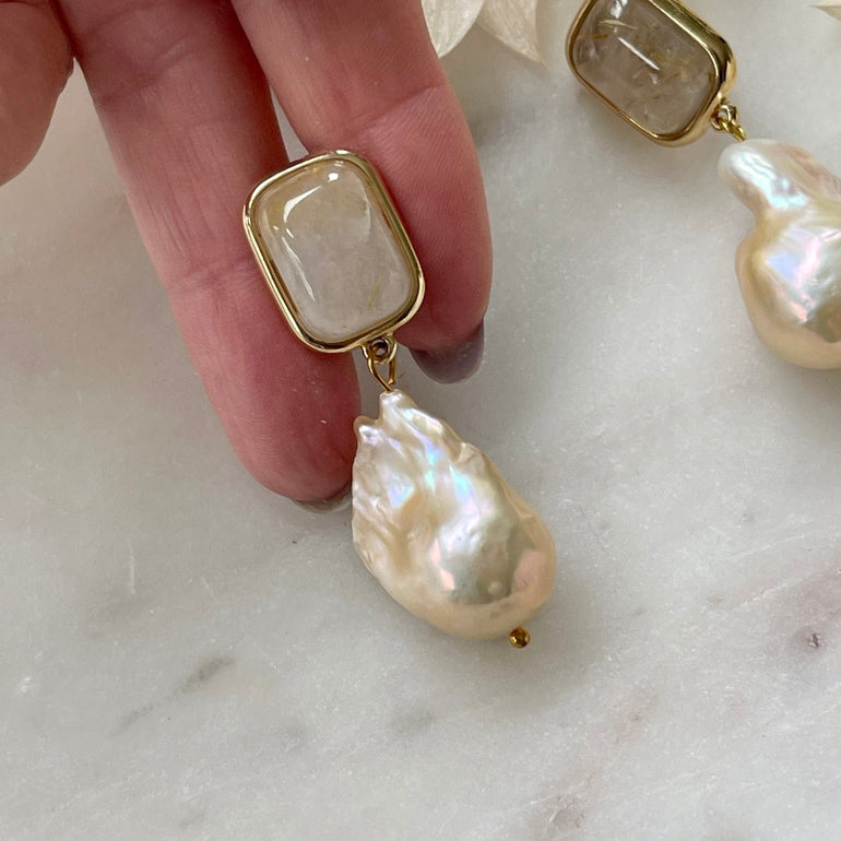 Die "ELLA" Ohrclips mit Rutil-Stein und Barockperlen verkörpern Eleganz und Natürlichkeit. Clip-Verschluss für Komfort. Länge: 4,5 cm, Breite: 1,4 cm (variiert aufgrund natürlicher Perlen). Gewicht: ca. 25,50 g/Paar.  Ein harmonisches Zusammenspiel von Natur und Stil.