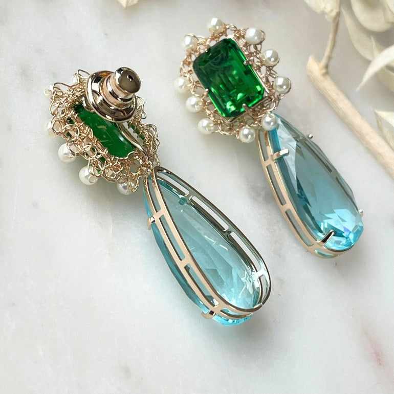 Ohrclips 'LILIBET' mit Smaragd, Aquamarin und Citrin Kristallen. Clip-Verschluss, 5,0 cm Länge, 1,5 cm Breite. 18 K vergoldetes Messing. Flexibel austauschbare Basis. Inklusive Extra-Kristallanhänger. Inspiriert von der Queen’s Jewelry Kollektion.