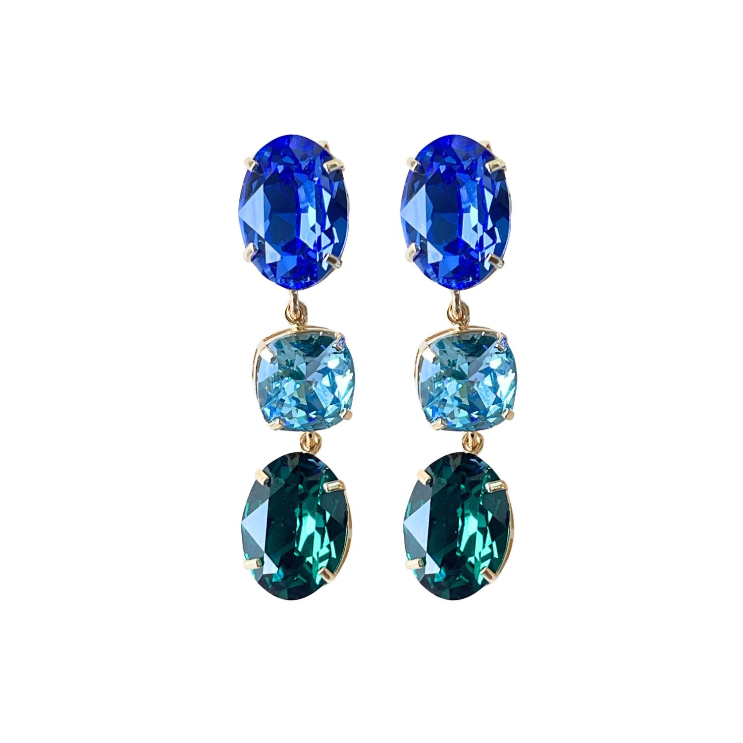 Alt-Text: "Entdecken Sie unsere "GLOW"-Ohrringe mit blau-grünen Kristallen. Die grüne Basis kann allein getragen werden und verleiht einen dezenten, aber wunderschönen Look. Die weltberühmten Kristalle sorgen für Glanz und zeitlose Eleganz."