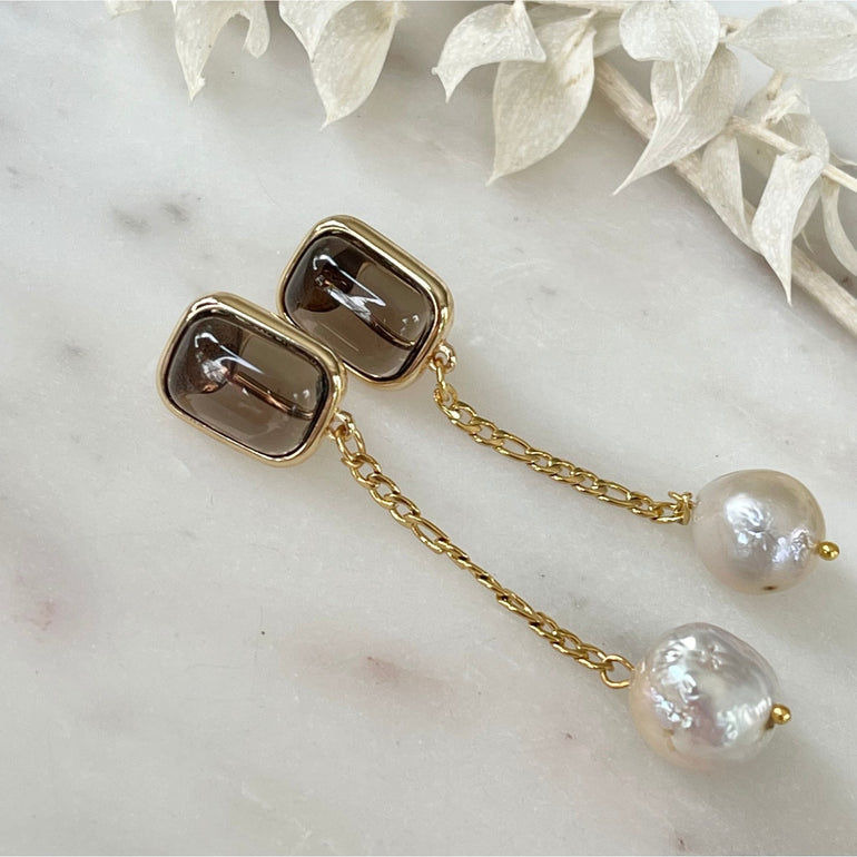 Die langen Perlenohrringe "MARTA" verströmen zeitlose Eleganz. Mit einem Längenmaß von 7,8 cm und einem CLIP-Verschluss bieten sie sowohl Stil als auch Bequemlichkeit. Ihre Breite beträgt etwa 1,2 cm, während das Paar insgesamt ein Gewicht von 18,31 g aufweist