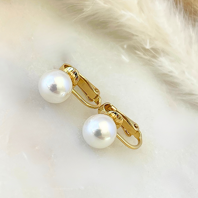 Detailaufnahme der vergoldeten Clip-Ohrringe LITTLE CHRISTA 7 mm mit schimmernden Shell-Perlen – eleganter Glanz und feine Oberfläche