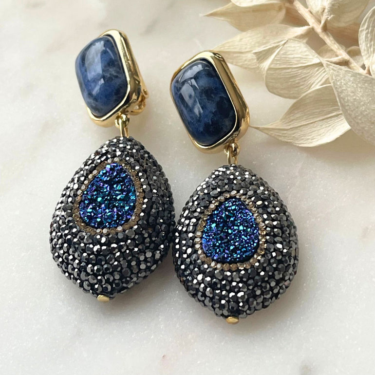 Elegante blaue Ohrringe mit Sodalith-Steinen und funkelnder Markasite. Perfekt für festliche Anlässe, verleihen sie subtile Raffinesse und zeitlose Schönheit. Der tiefblaue Sodalithstein bringt ruhige Eleganz, während die schimmernden Markassite-Details einen Hauch von Glamour hinzufügen