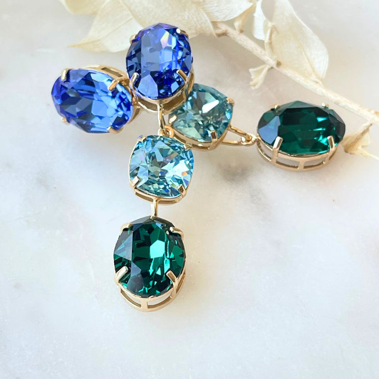 Entdecken Sie unsere "GLOW"-Ohrringe mit blau-grünen Kristallen. Die grüne Basis kann allein getragen werden und verleiht einen dezenten, aber wunderschönen Look. Die weltberühmten Kristalle sorgen für Glanz und zeitlose Eleganz.