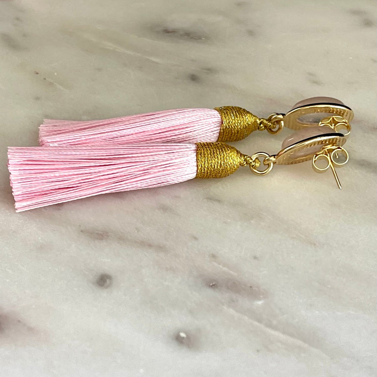 Rosa Rosenquarz und Quasten. Stecker-Verschluss. Gewicht: 10 g/Paar. Maße: Länge ca. 8 cm, Breite 1,3 cm. 18 K vergoldetes Messing. Stilvoll und hochwertig. Rosenquarz symbolisiert zarte Stärke. Moderne Quasten für jugendliche Frische