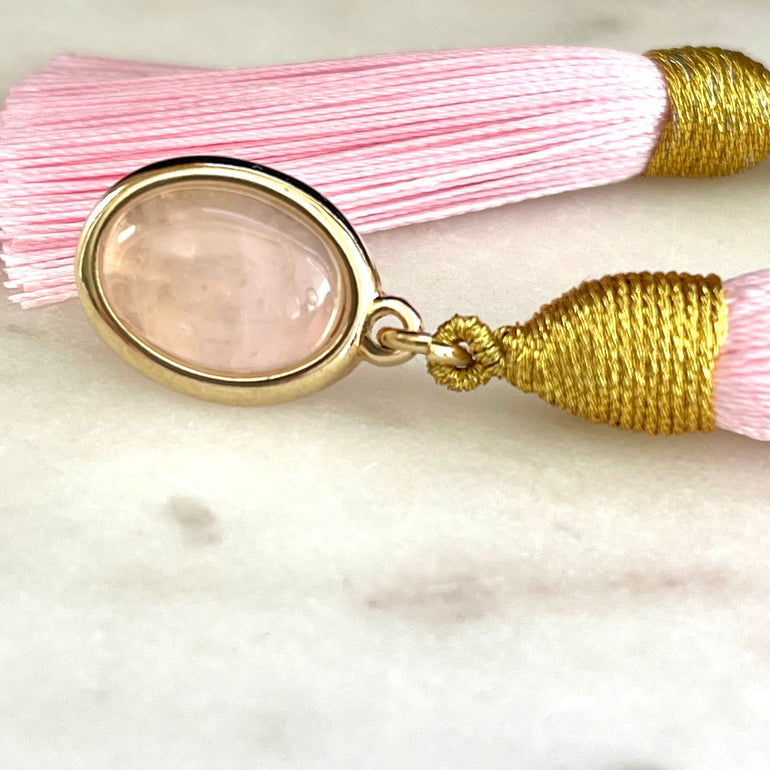 Rosa Rosenquarz und Quasten. Stecker-Verschluss. Gewicht: 10 g/Paar. Maße: Länge ca. 8 cm, Breite 1,3 cm. 18 K vergoldetes Messing. Stilvoll und hochwertig. Rosenquarz symbolisiert zarte Stärke. Moderne Quasten für jugendliche Frische