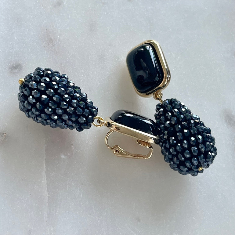 Ohrclips CHARLOTTE mit schwarzem Achat: Zeitlose Eleganz. Clip-Verschluss, 18 K vergoldetes Messing. Länge 4,8 cm, Breite 1,3 cm. Mit Kristall-Anhänger für zeitgenössisches Flair. Einfach anzubringen und bequem zu tragen