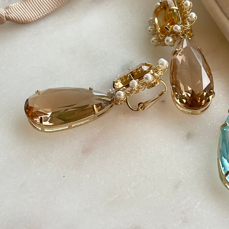 Ohrringe mit Kristallen Citrin und Aquamarin - Mit Clip-Verschluss - Länge: 5,0 cm. Enthält einen kompletten Ohrring und ein Paar zusätzliche Kristallanhänger in anderer Farbe - Inspiriert von der Queen’s Jewelry Kollektion - Bietet Flexibilität für verschiedene Looks und Stile.