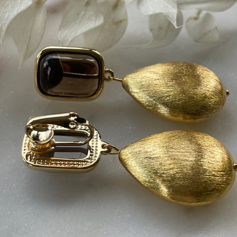 Ohrclips BELLA mit Rutil: Glamouröser Blickfang. Clip-Verschluss, 18 K vergoldetes Messing. Strahlender Rutil in Kombination mit goldenem Tropfen. Länge 5,0 cm, Breite 1,5 cm. Farbe: Gold. Perfekt für besondere Anlässe und den Alltag